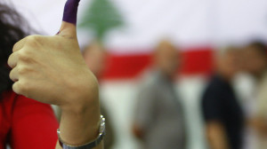 A Lebanese election staff shows her ink-stained finger after casting her vote at a polling station in Beirut