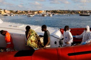 Migrants who survived a shipwreck arrive at the Lampedusa harbour