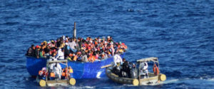 Migrants sit in their boat during a rescue operation by Italian navy ship Borsini (unseen) off the coast of Sicily, Italy, in this handout picture courtesy of the Italian Marina Militare released on July 19, 2016. Marina Militare/Handout via REUTERS ATTENTION EDITORS - THIS PICTURE WAS PROVIDED BY A THIRD PARTY. FOR EDITORIAL USE ONLY.